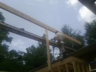 Carpenter setting a ridge beam over a new addition frame — Ice Dam Removal by Roofing Brothers in Hopkinsville