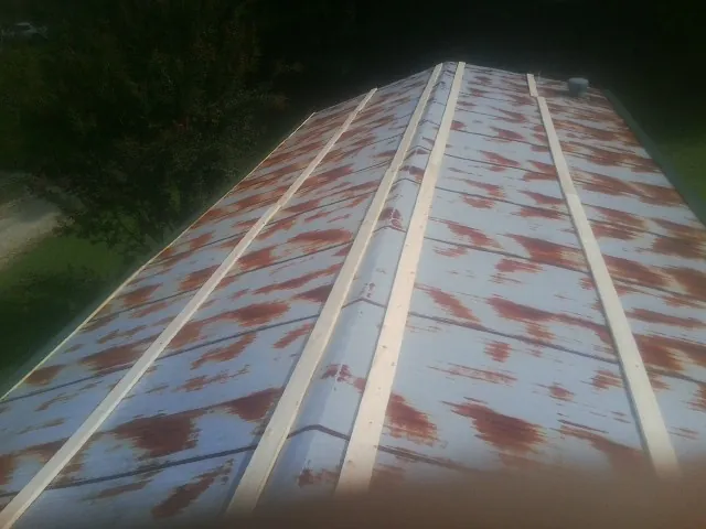 Rusted metal roof panels with new wood purlins before replacement — Storm Damage Roof Repair in Hopkinsville by Roofing Brothers