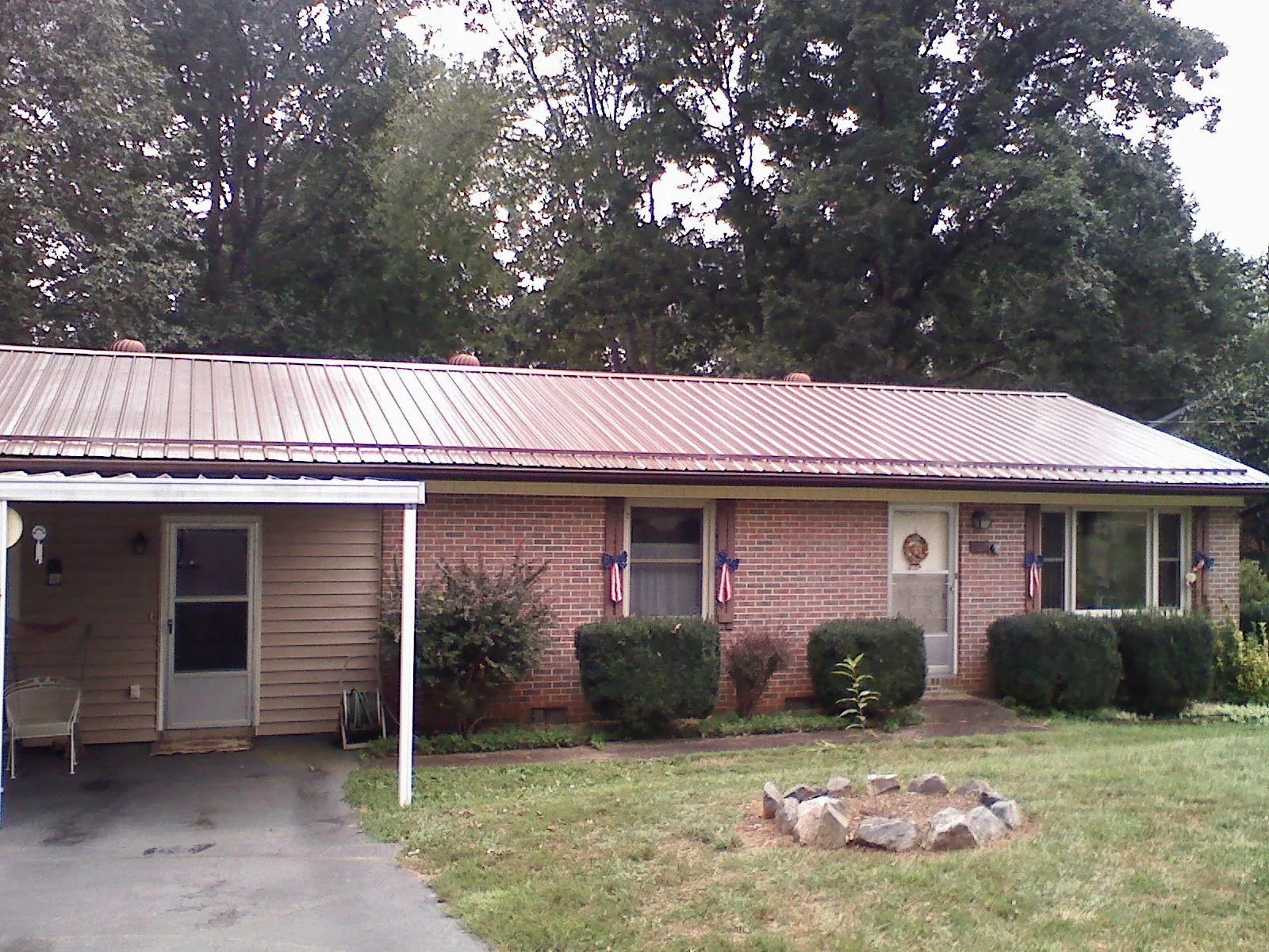 Bronze metal roof and carport on a brick ranch home — Roof Repair work by our crew in Hopkinsville