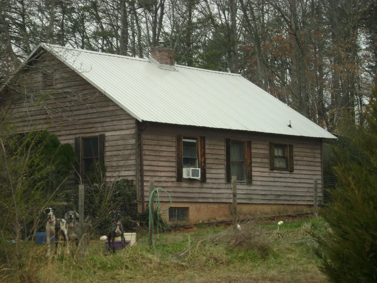 White metal roof on an old wood sided farmhouse, from a Metal Roof Installation job in Hopkinsville